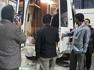 Un client du Bangladesh vient à l'usine et étudie un camion à fond plat et une voiture de tourisme